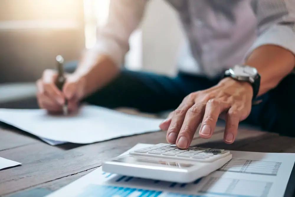 Executive calculating how much you are saving by having contractor liability insurance.